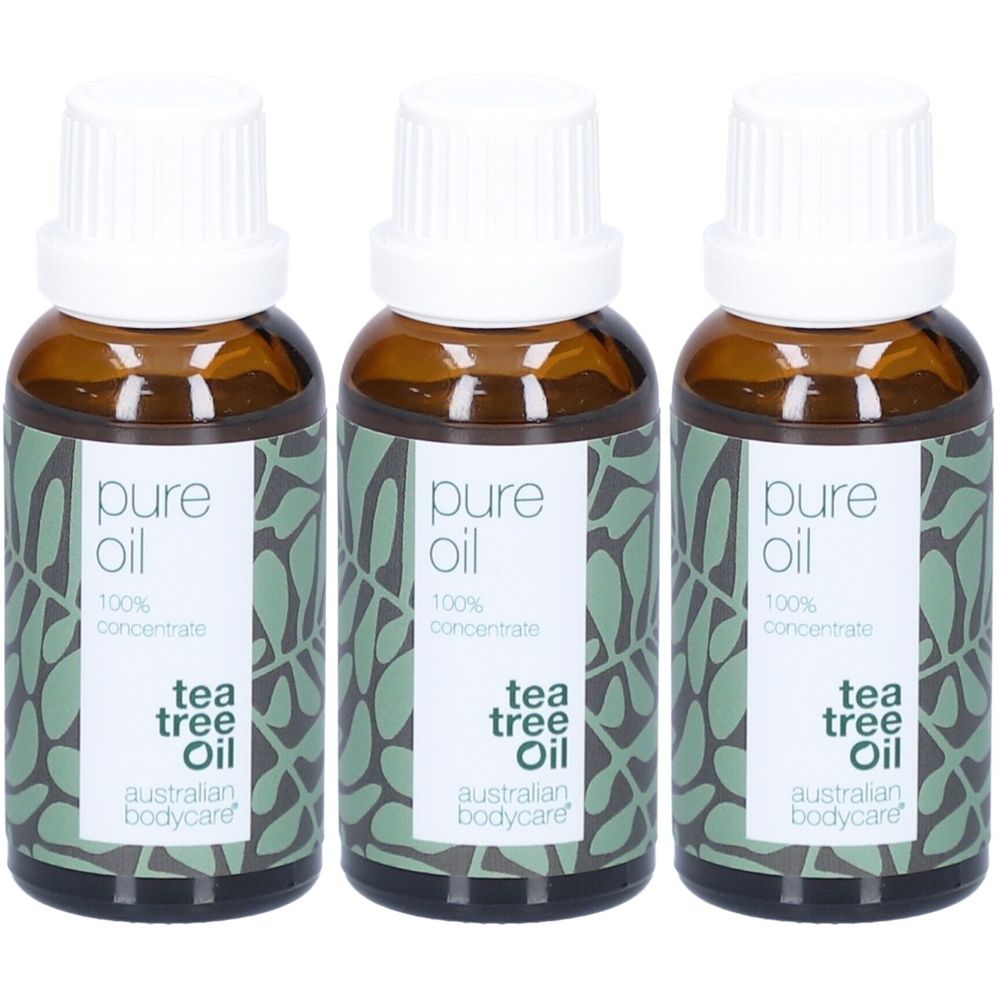 Trois flacons d'huile d'arbre à thé. Flacons en verre brun avec bouchons blancs. Étiquette avec texte : pure oil, 100% concentrate, tea tree oil, australian bodycare.