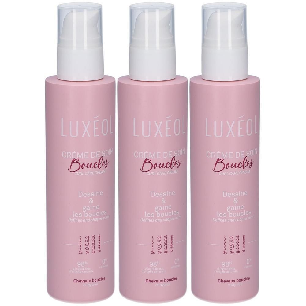 Drie roze flessen met witte pomp. Opschrift: LUXÉOL Crème de Soin Boucles. Tekst: Dessine & gaine les boucles.