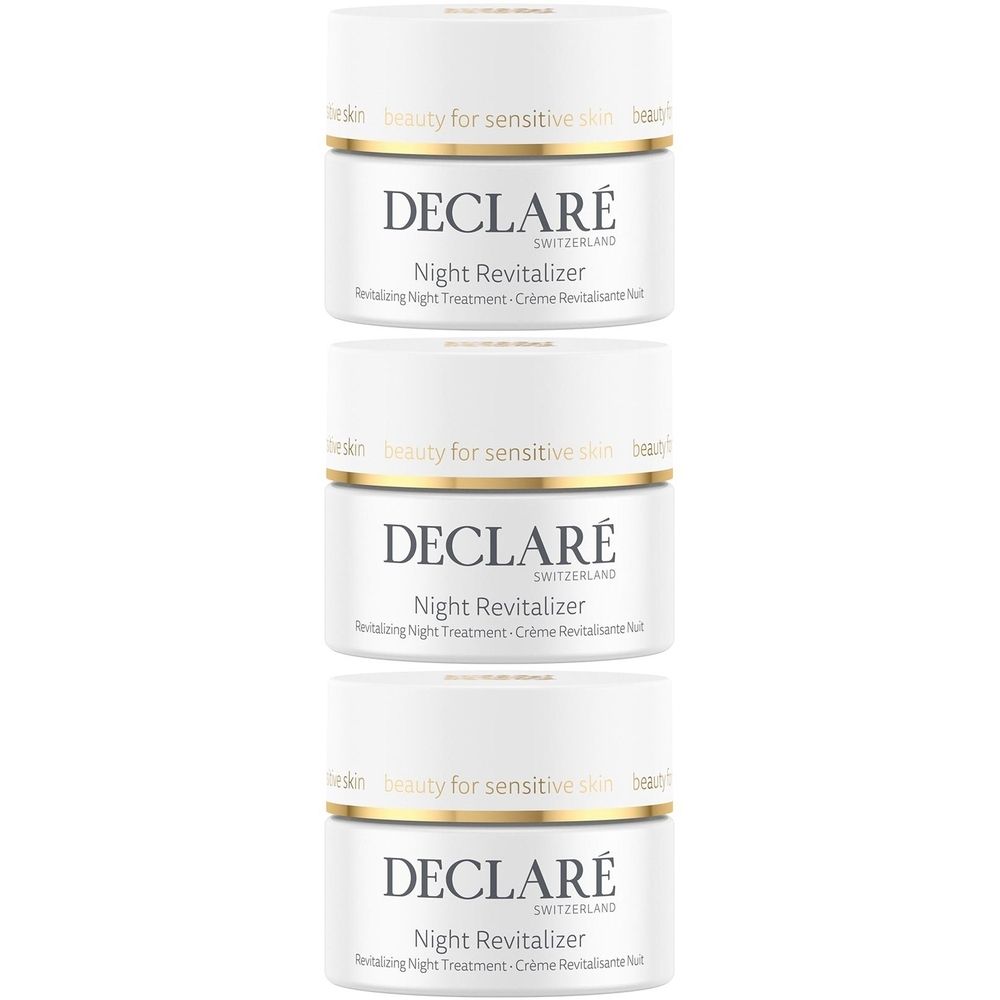 Trois pots blancs avec des bordures dorées. Chaque pot porte l'inscription "DECLARÉ Switzerland Night Revitalizer".