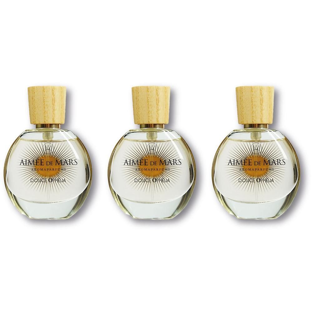 Trois flacons ronds en verre avec bouchon en bois clair, remplis de parfum clair.