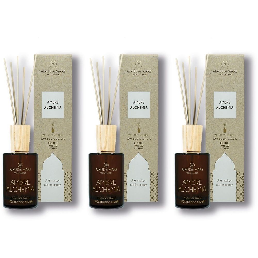 Trois diffuseurs d'ambiance avec flacons bruns, bouchons en bois et bâtonnets. Emballage carton avec nom et logo.