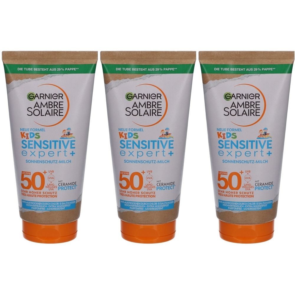 Trois tubes de lait solaire Garnier Ambre Solaire Kids Sensitive Expert+. Tubes blancs, bouchons orange, SPF 50.