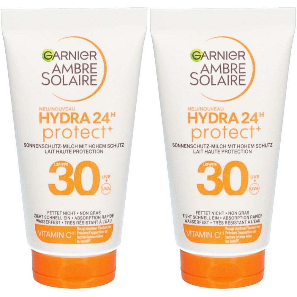 Twee tubes Garnier Ambre Solaire zonnebrandmelk SPF 30. Witte tubes met oranje doppen. Tekst: Hydra 24H protect+ en vitamine C.