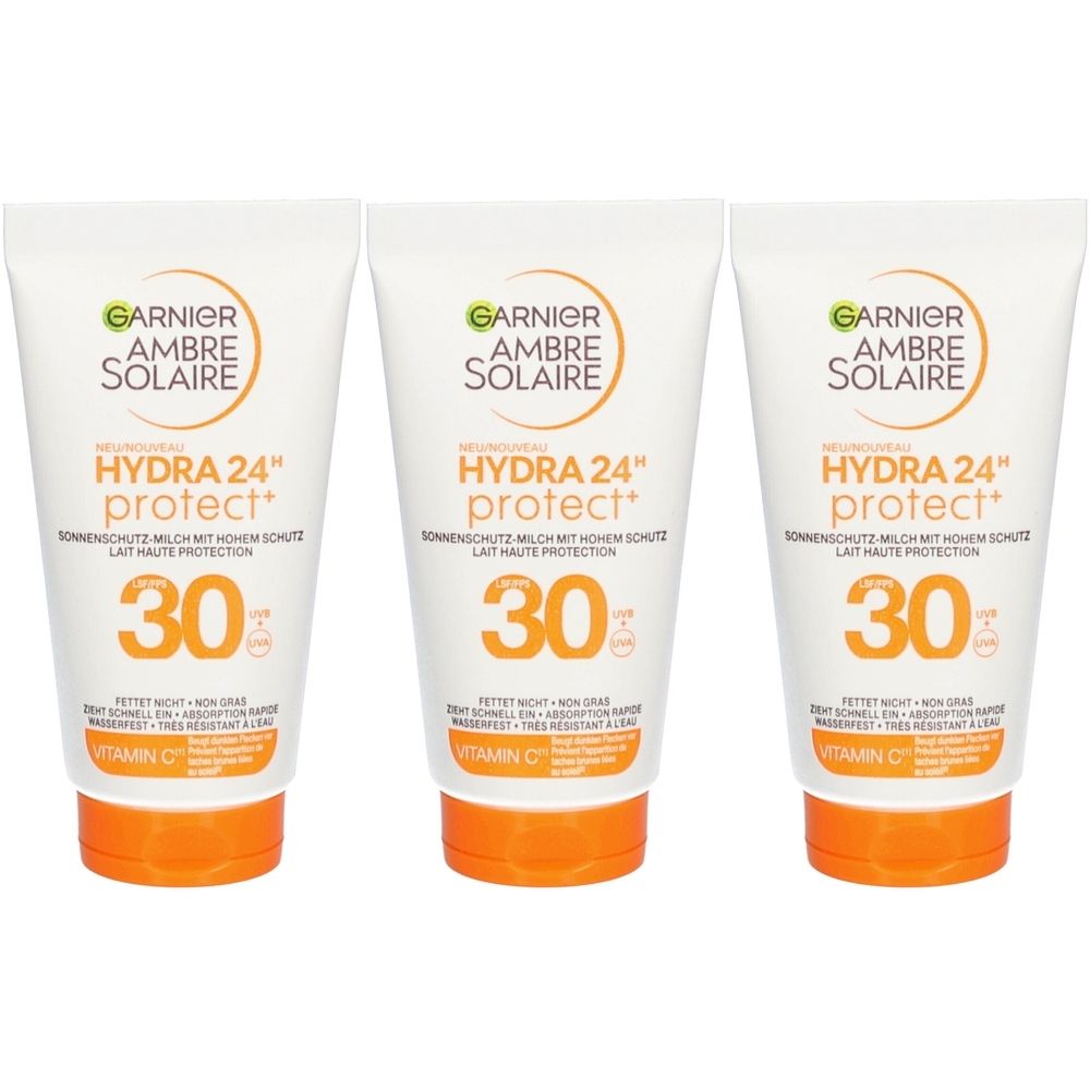 Drie tubes Garnier Ambre Solaire zonnebrandmelk SPF 30. Witte tubes met oranje doppen. Tekst: Hydra 24 protect, vitamine C.