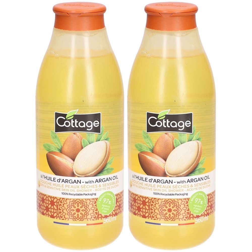 Twee flessen doucheolie met arganolie. Opschrift "Cottage". Gele vloeistof in transparante flessen. Oranje dop.