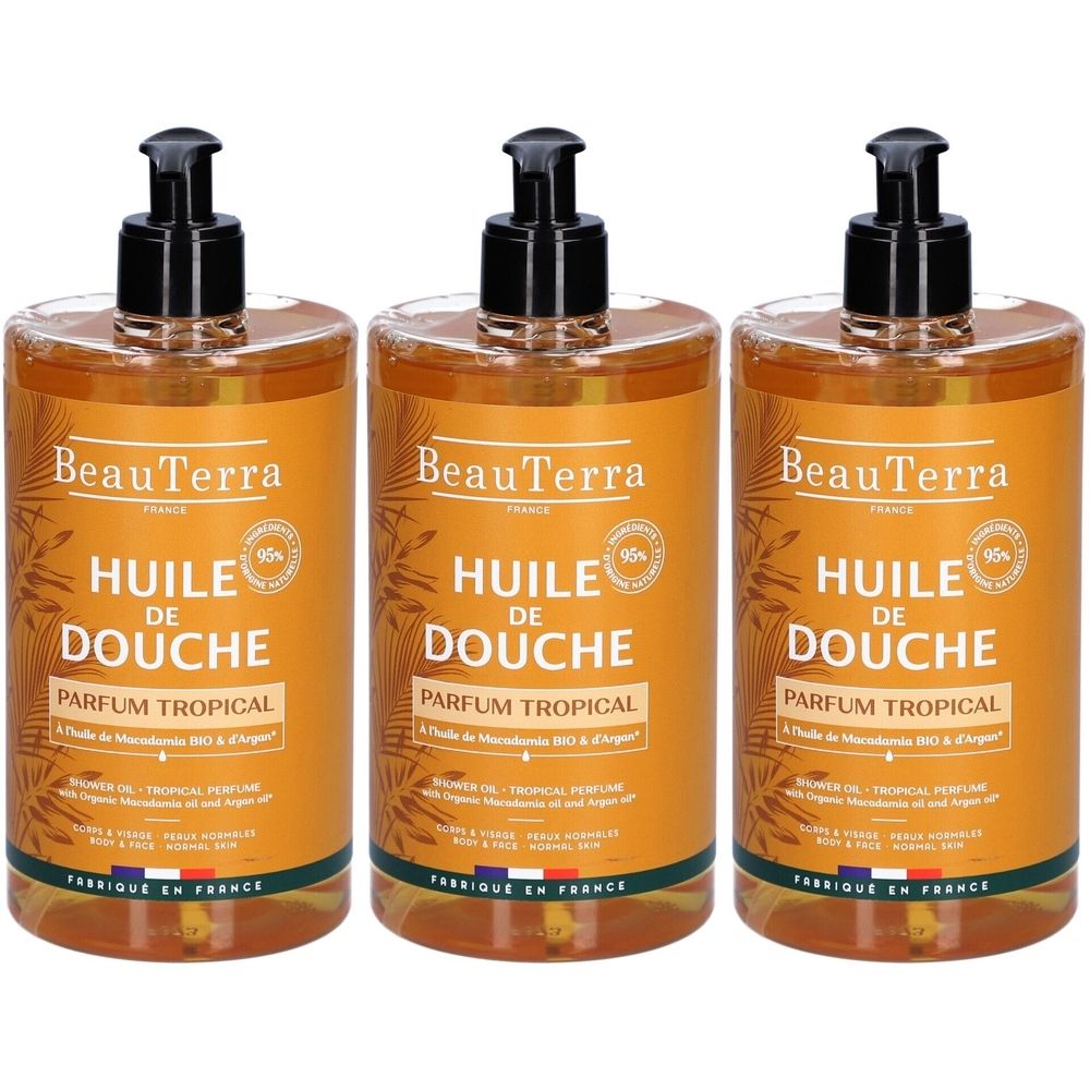Drie flessen douche-olie met zwarte pomp. Opschrift: BeauTerra, Huile de Douche, Parfum Tropical. 95%.