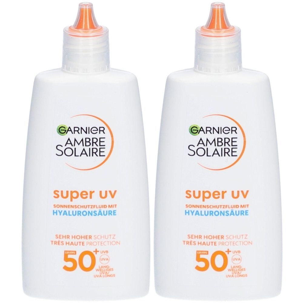 Twee witte flessen Garnier Ambre Solaire Super UV SPF 50+. Opschrift: Hyaluronzuur, Zeer hoge bescherming.