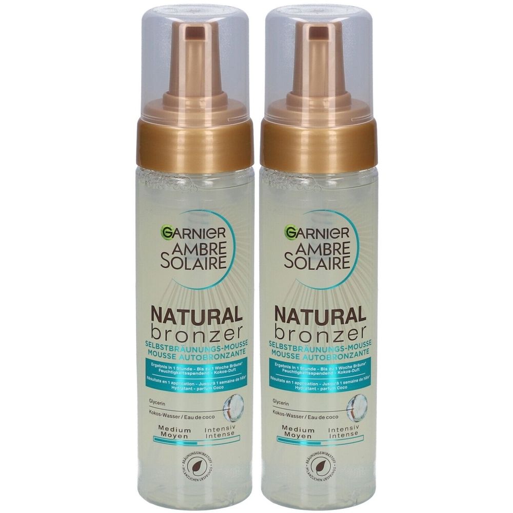 Twee flessen Garnier Ambre Solaire Natural Bronzer zelfbruiningsmousse. Transparante flessen met gouden doppen en opschrift.