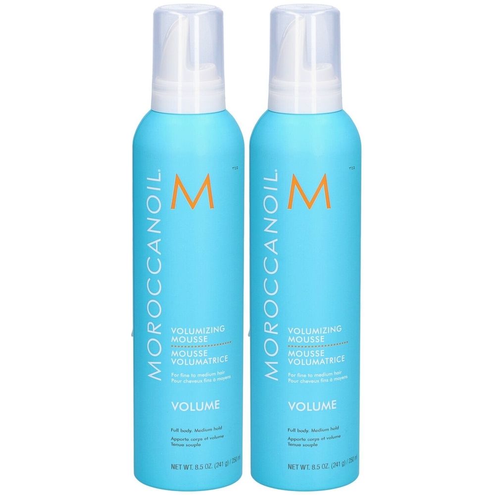 Deux flacons bleus avec vaporisateur blanc. Inscription : MOROCCANOIL, VOLUMIZING MOUSSE, VOLUME. Logo orange.