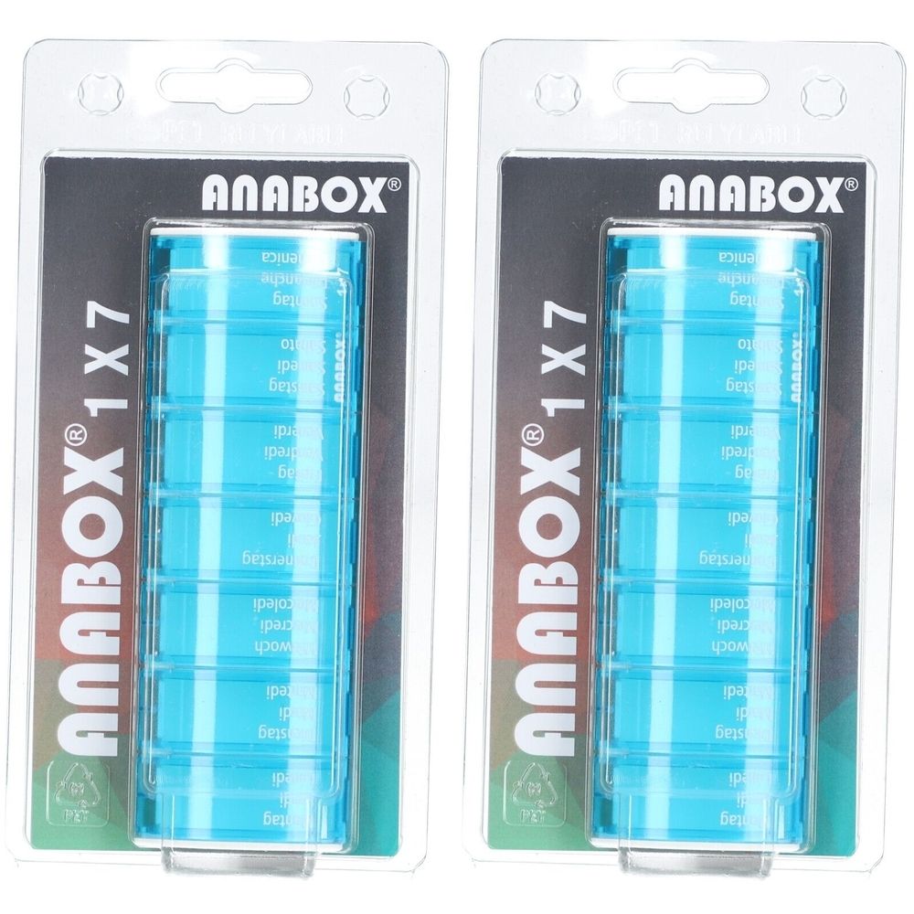 Twee medicijndispensers in blisterverpakking. Turquoise rechthoekige dispensers met zeven compartimenten. Opschrift "ANABOX 1x7".