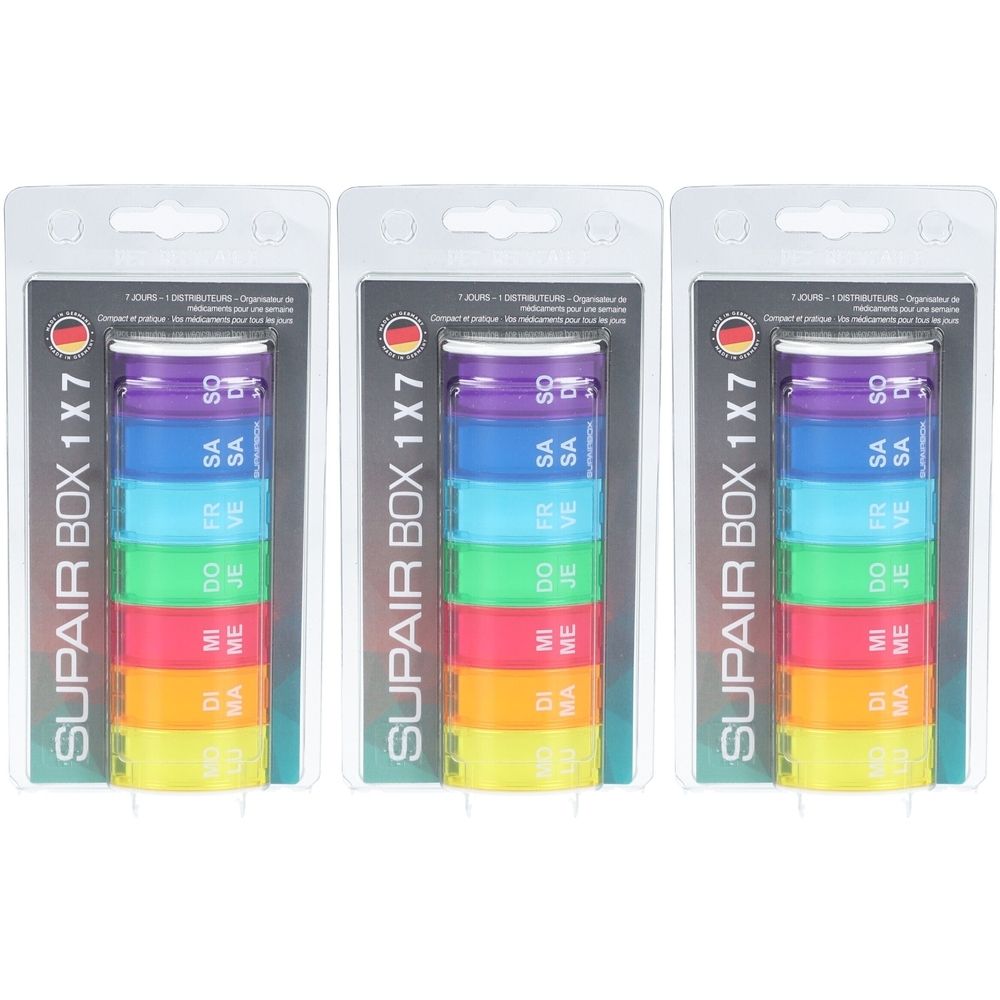 Drie verpakkingen van een wekelijkse pillendoos. Elke doos heeft zeven gekleurde compartimenten met weekdagen. Opschrift: SUPAIR BOX 1X7.