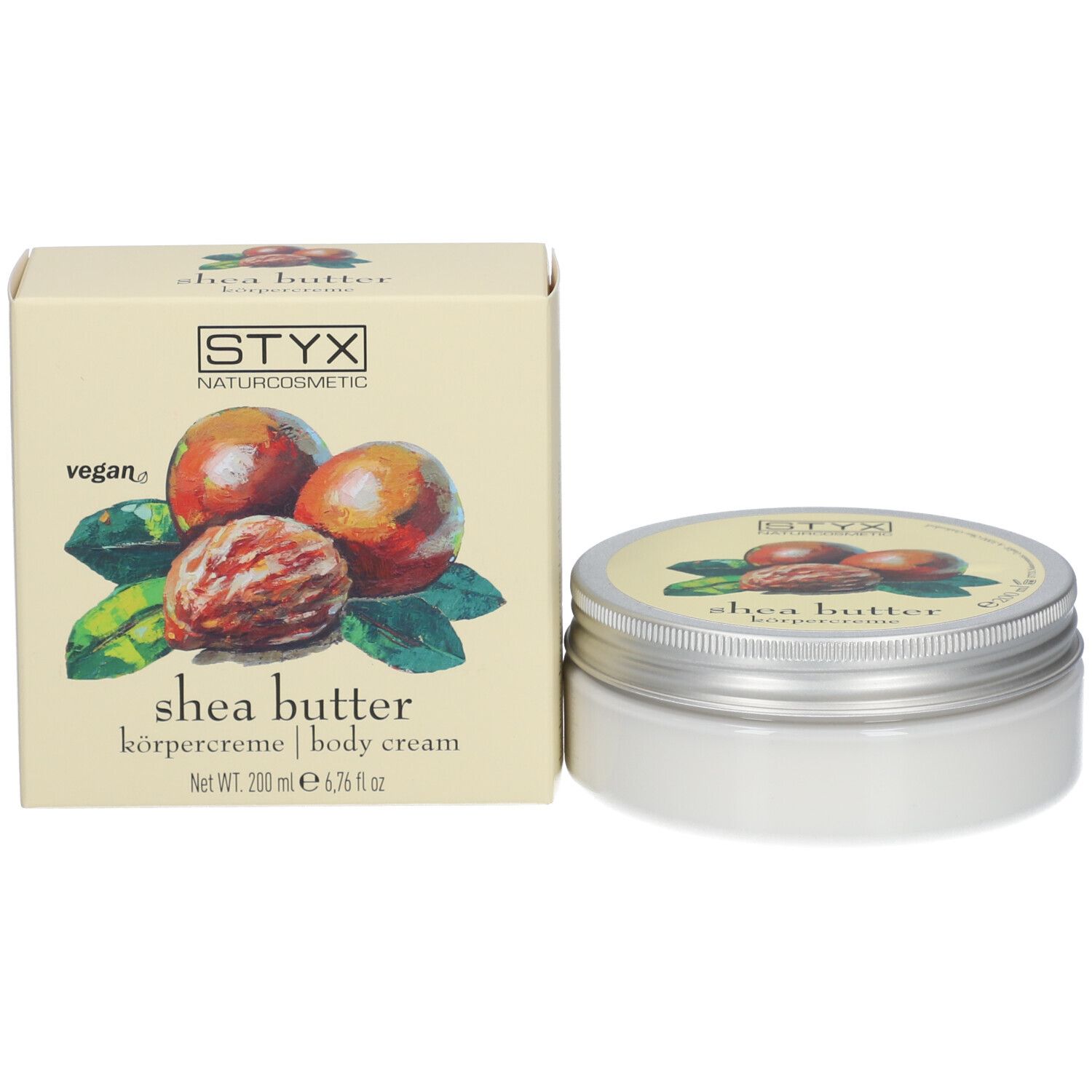 Crèmepot en doos. Op pot en doos: STYX, sheabutter bodycrème. Doos met afbeelding van sheanoten en bladeren.