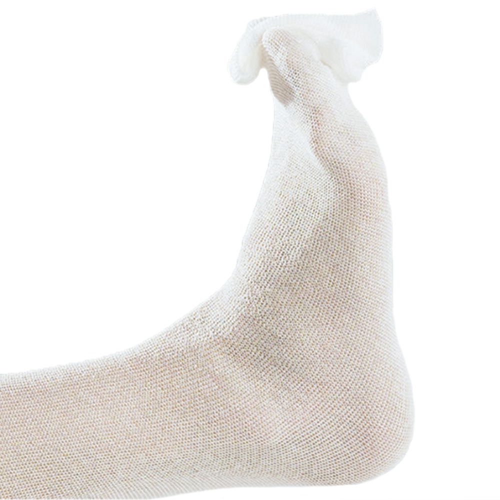 Witte buisverband, gedragen op de voet. Geweven materiaal.