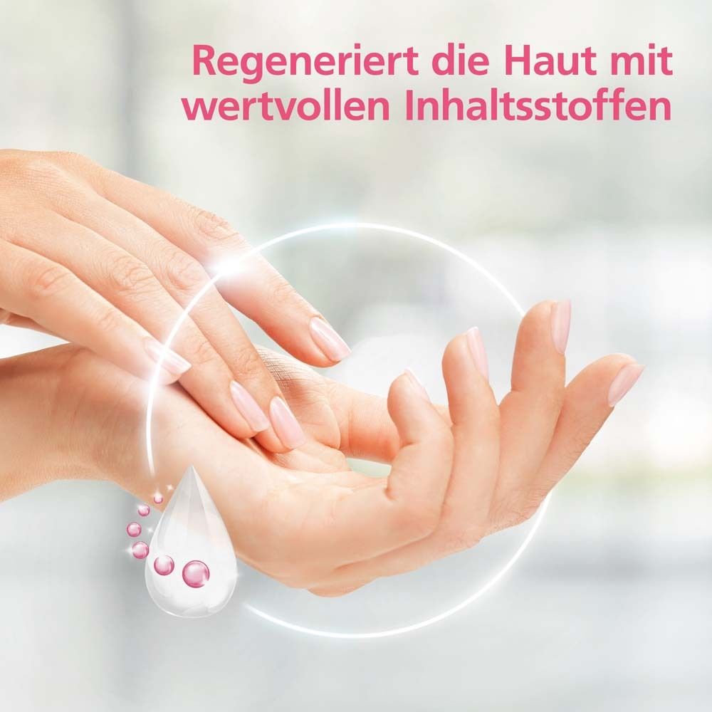 Handen met crème. Druppelsymbool. Achtergrond onscherp.