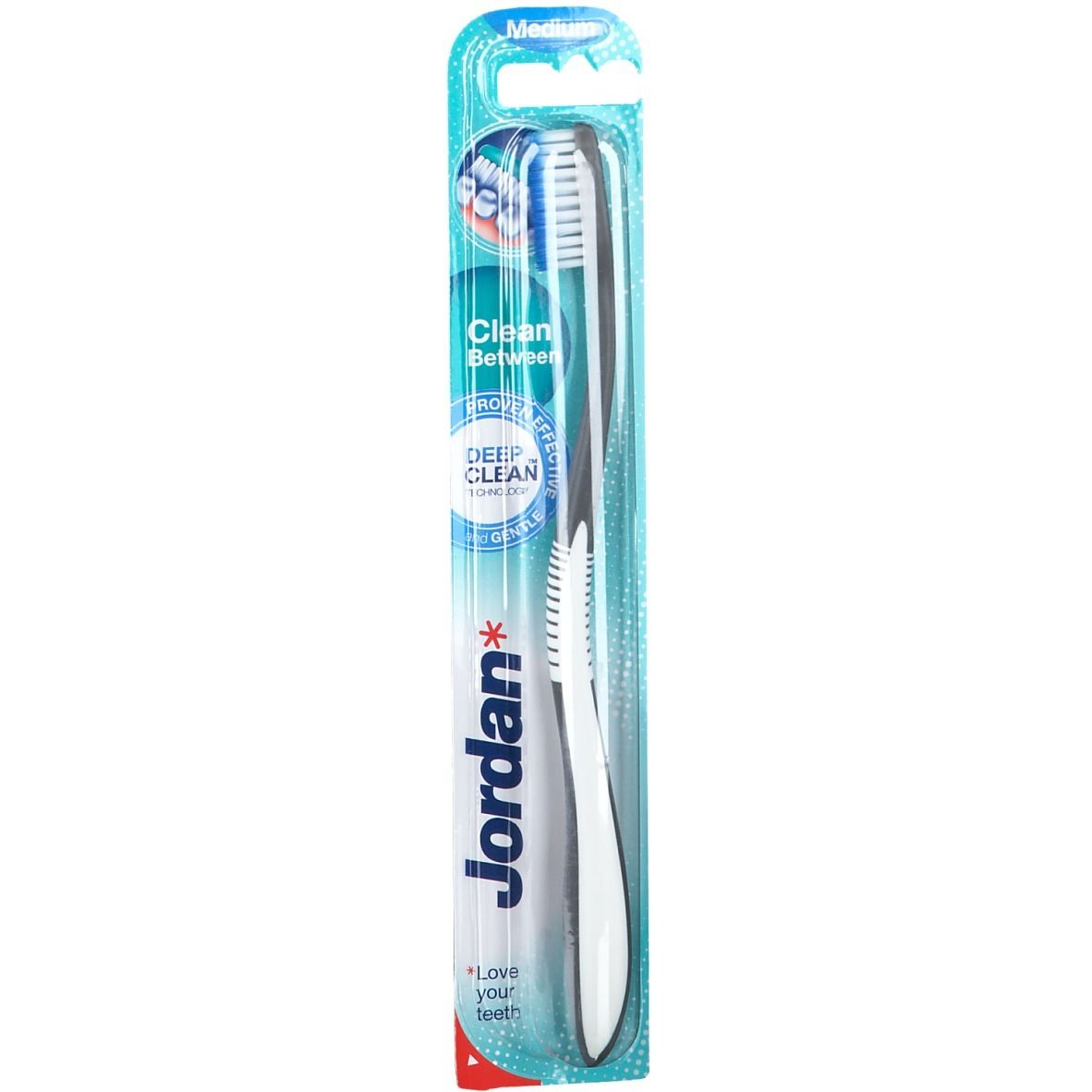 Brosse à dents Jordan Clean, moyenne, en blister. Manche noir, tête blanche. Emballage bleu avec informations produit.