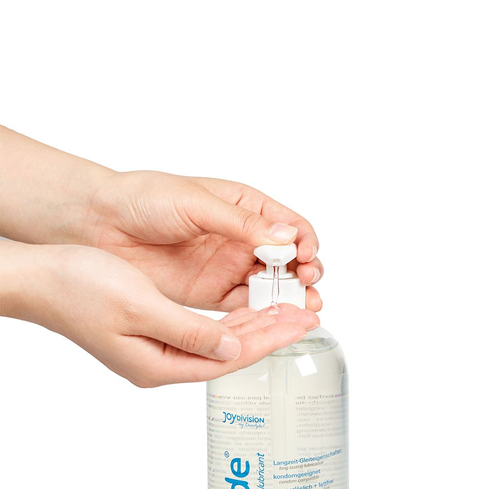 Mains pressant le distributeur de gel lubrifiant AQUAGLIDE.