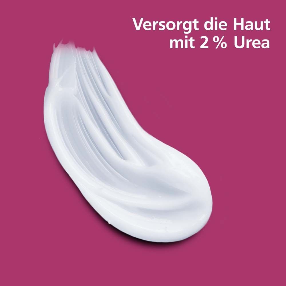 Produit blanc sur fond rose. Texte : Fournit à la peau 2 % d'urée.