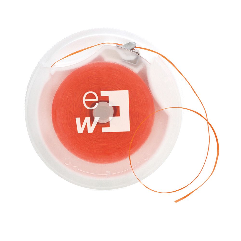 Bobine de fil dentaire orange dans un boîtier transparent. Logo "ew" et croix.