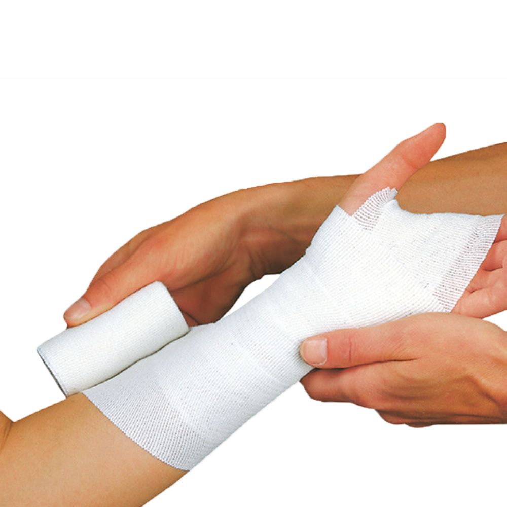 Un bandage blanc est appliqué sur un bras. Un rouleau est à côté.