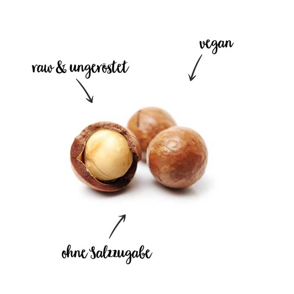 Drie macadamia-noten, één open. Tekst: rauw & ongeroosterd, zonder zout, veganistisch.