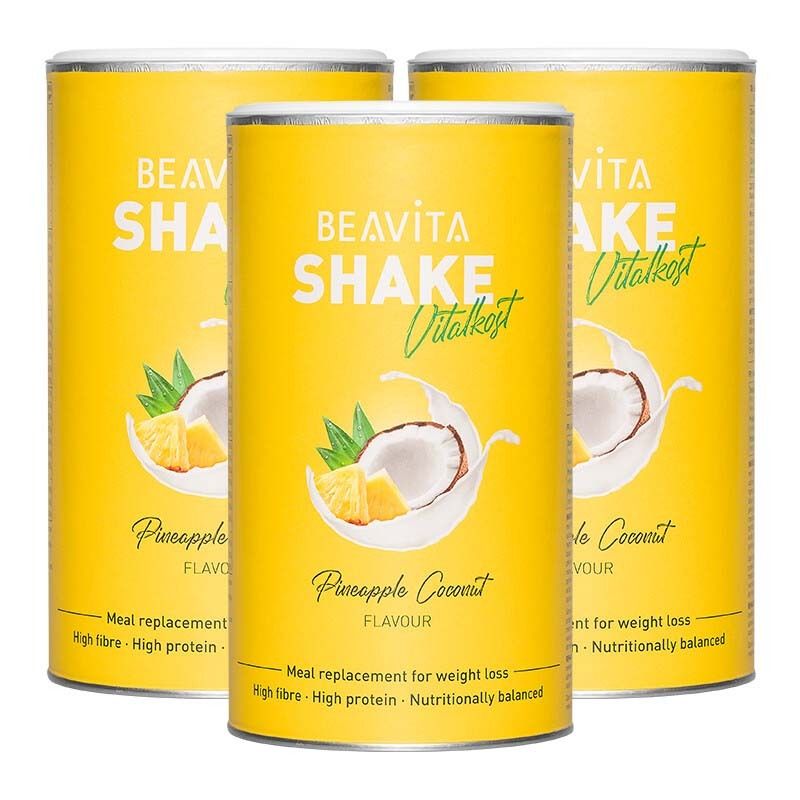 Trois boîtes jaunes BEAVITA Shake saveur Coco-Ananas, entourées de noix de coco et d'ananas.