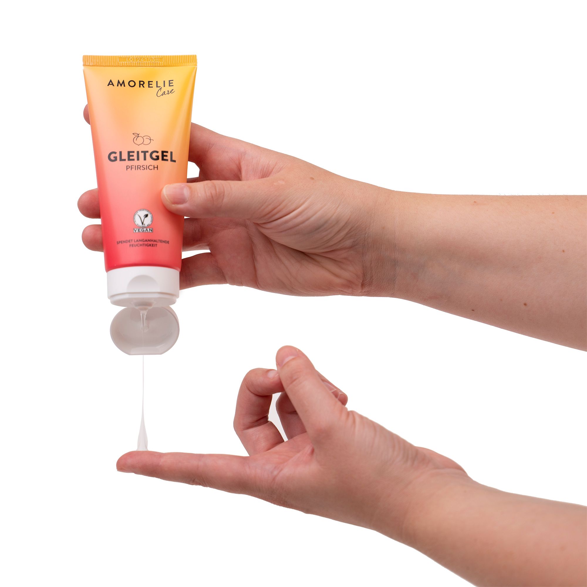 Mains pressant du gel hors du tube. Nom du produit non visible. Liquide sur les doigts.