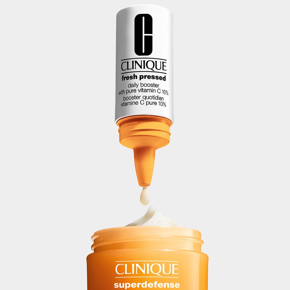 Een fles met de tekst "CLINIQUE fresh pressed" wordt boven een pot crème gehouden.