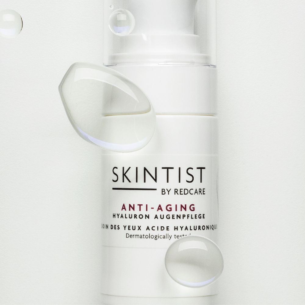Witte fles met pomp. Opschrift: SKINTIST BY REDCARE ANTI-AGING Hyaluron Augenpflege. Waterbellen.