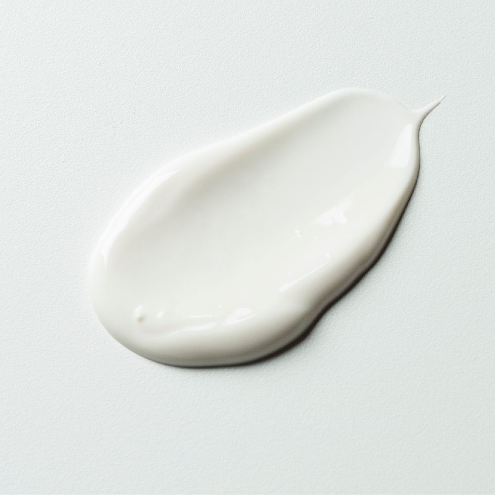 Witte crèmevlek op lichte achtergrond. Textuur zichtbaar.