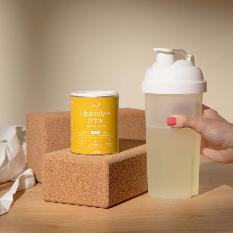 Nu3 Elektrolyte Drink blik naast een shaker met drank.