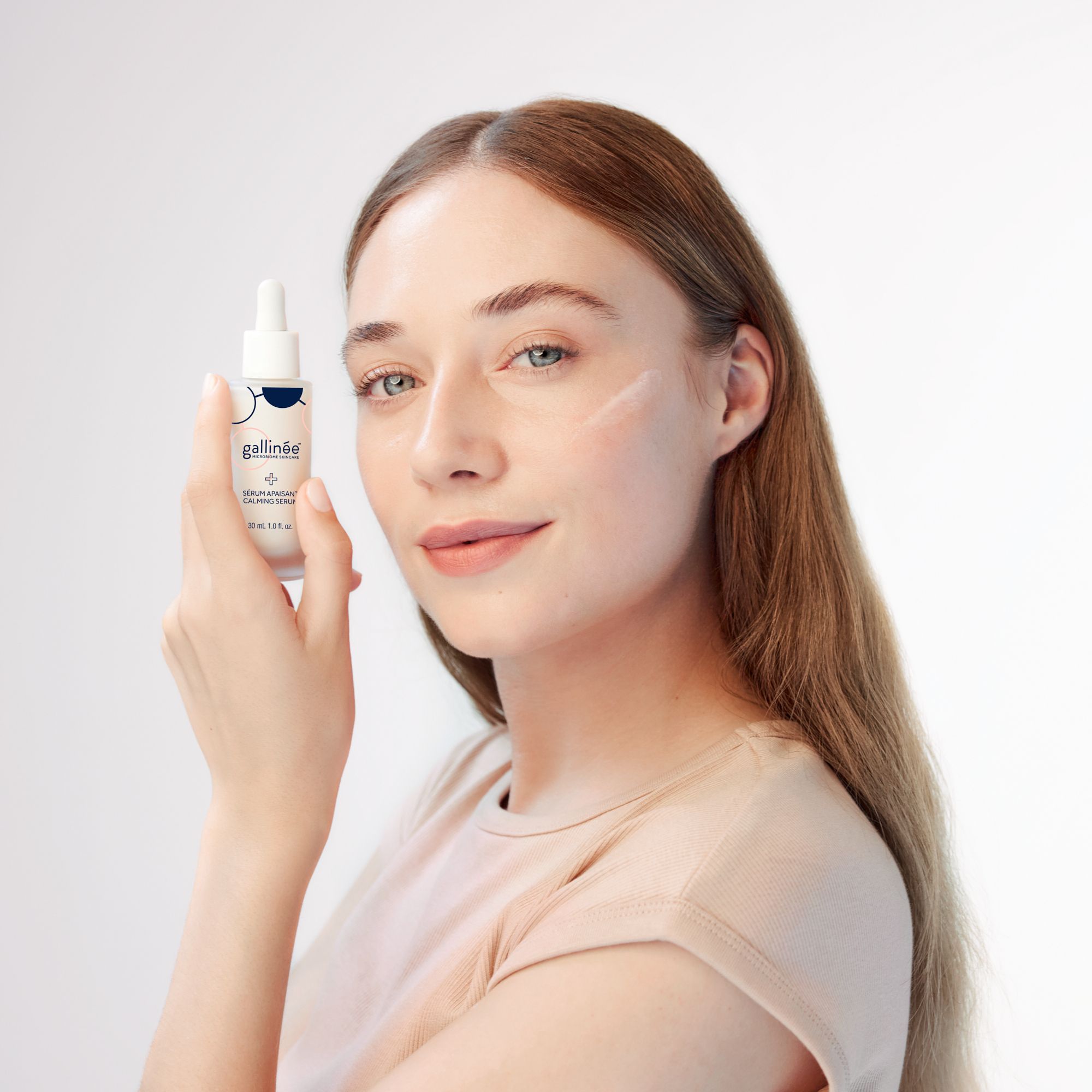 Vrouw houdt serumfles vast. Merk: Gallinée. Opschrift: Calming Serum. 30 ml.