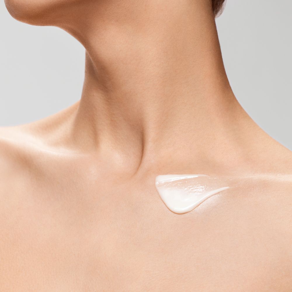 Une crème blanche est appliquée sur le décolleté.