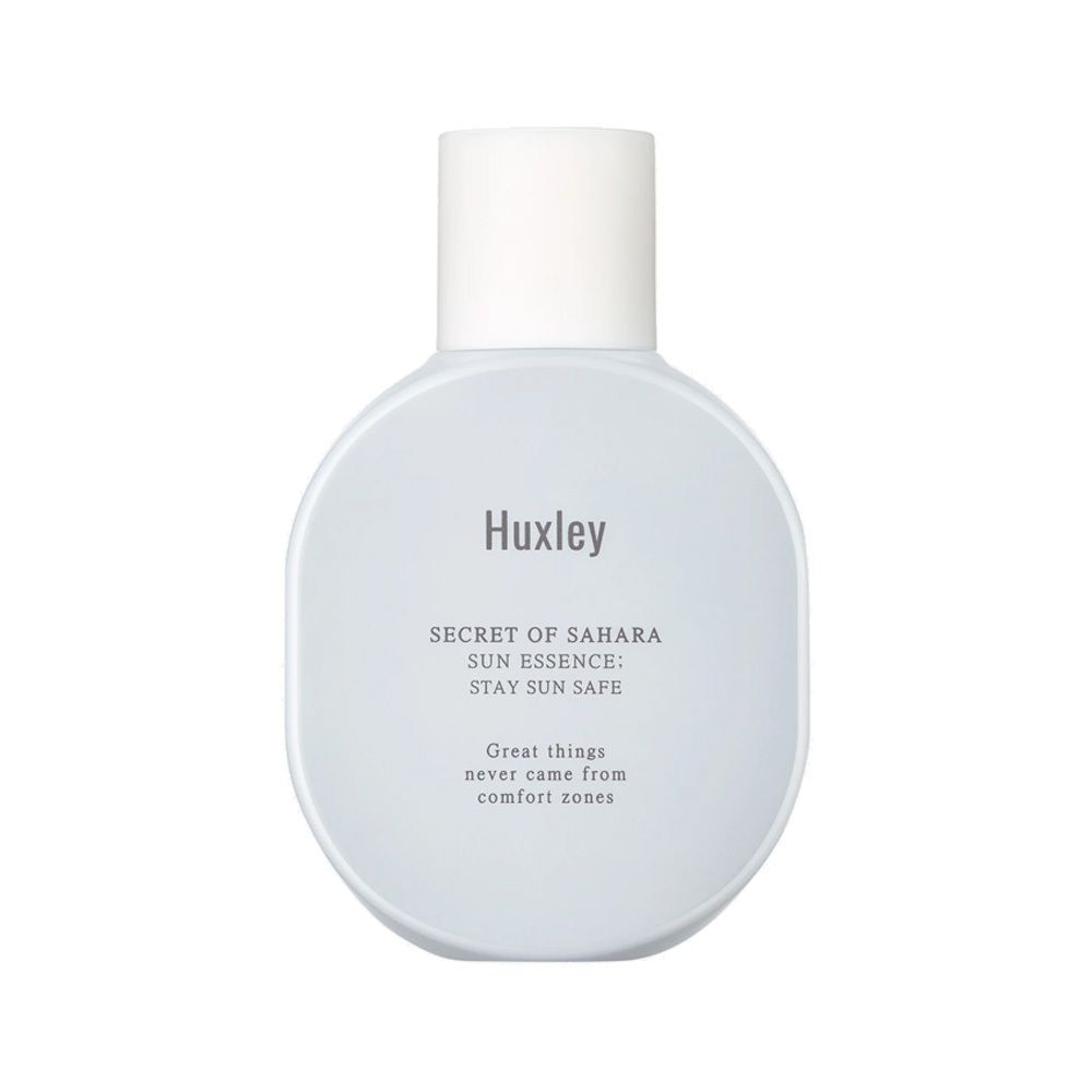 Lichtblauwe fles met witte dop. Opschrift: Huxley, SECRET OF SAHARA, SUN ESSENCE, STAY SUN SAFE. Tekst: Great things never came from comfort zones.