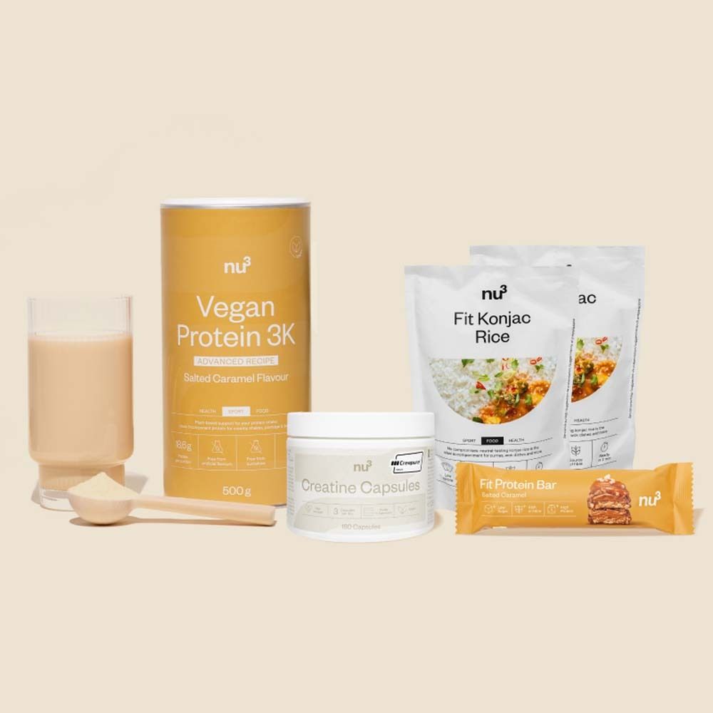 Fitness supplementen: vegan proteïne, Konjac rijst, creatine capsules en eiwitreep. Op lichte achtergrond.
