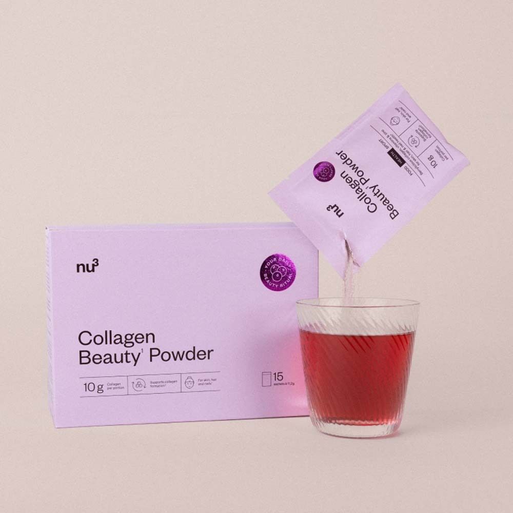 Roze verpakking en sachet met Collagen Beauty' Powder. Poeder wordt in glas gegoten.