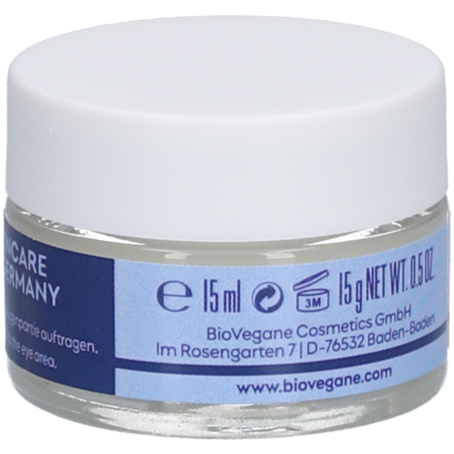 Oogcrèmetiegel met witte deksel. Blauwe band met tekst: e 15ml. BioVegane Cosmetics GmbH. 15g NET WT. 0.5 OZ.