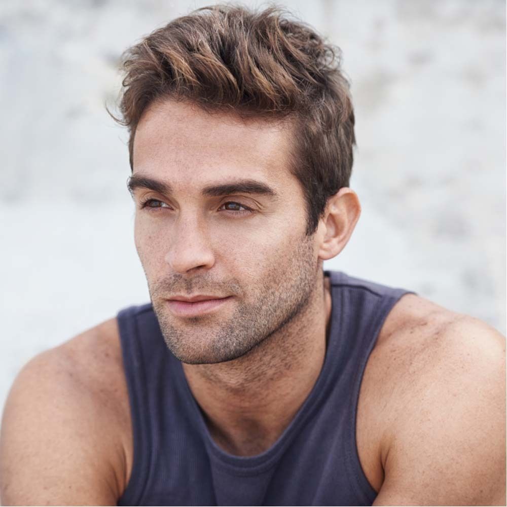 Portret van een man met bruin haar en baard. Hij kijkt nadenkend.