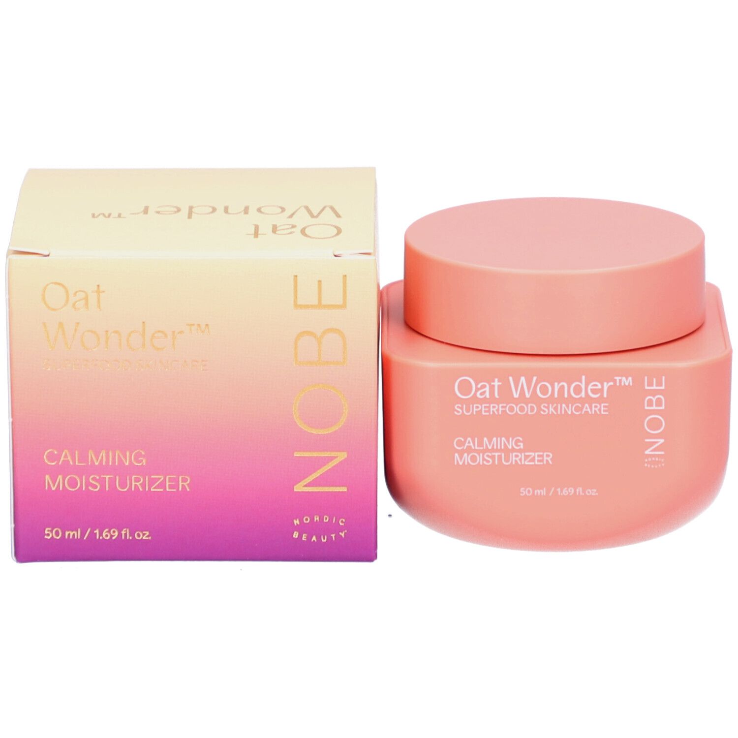 NOBE Oat Wonder Kalmerende Moisturizer (50 ml) naast de bijpassende roze en paarse doos. "Oat Wonder", "Superfood Skincare", "Calming Moisturizer" en "NOBE" zijn op beide gedrukt.