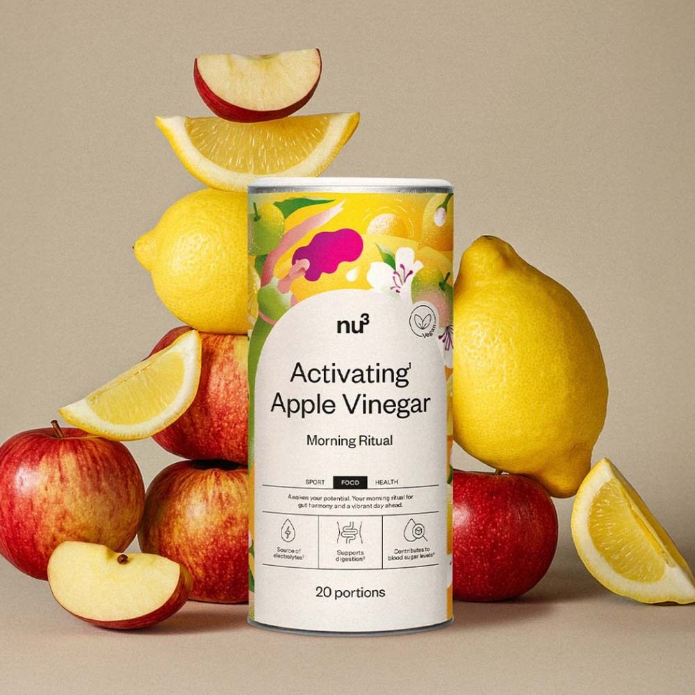 Doos "nu3 Activating Apple Vinegar" omringd door appels en citroenen. Productnaam en logo zichtbaar. 20 porties.