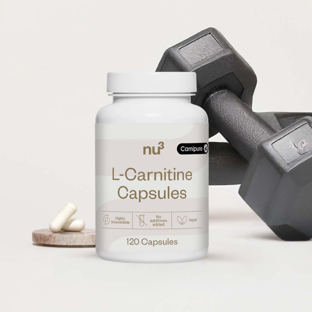 Flacon blanc avec étiquette. Inscription: nu3 L-Carnitine Capsules, 120 capsules. Logos: hautement biodisponible, sans additifs, végétalien. Capsules et haltère.