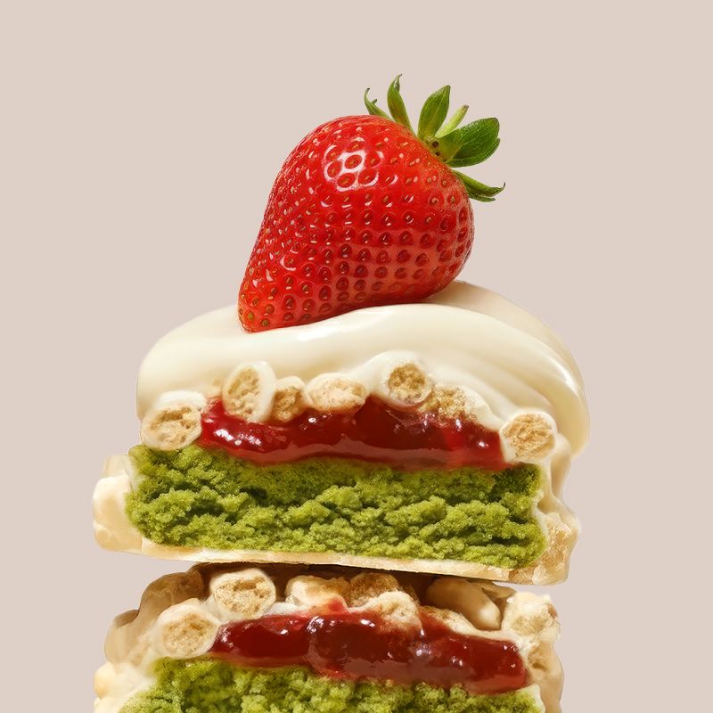 Gedetailleerd beeld van een Aardbei-Matcha proteïnereep met witte chocolade, aardbei en matcha vulling.