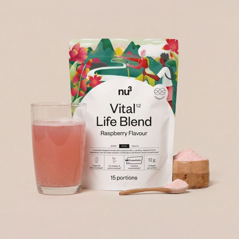 Verre de boisson à la framboise, sachet nu3 Vital Life Blend, cuillère avec poudre et bol en bois.