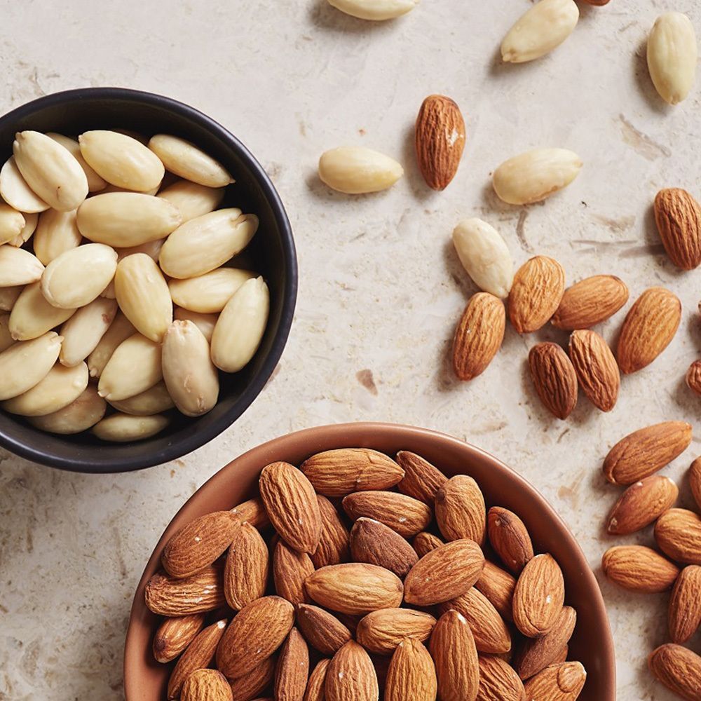 Bol avec amandes émondées et bol avec amandes non émondées.