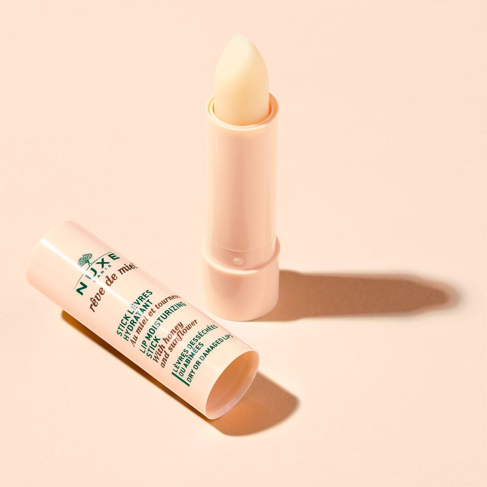 Lippenbalsem en huls op crèmekleurige achtergrond. Huls ernaast.