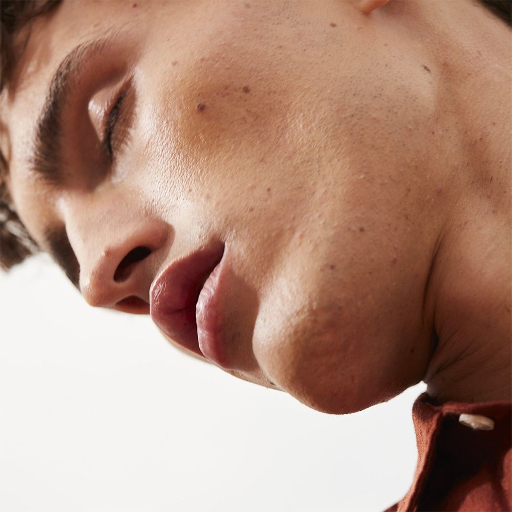 Close-up van een man met gesloten ogen. Licht geopende lippen.