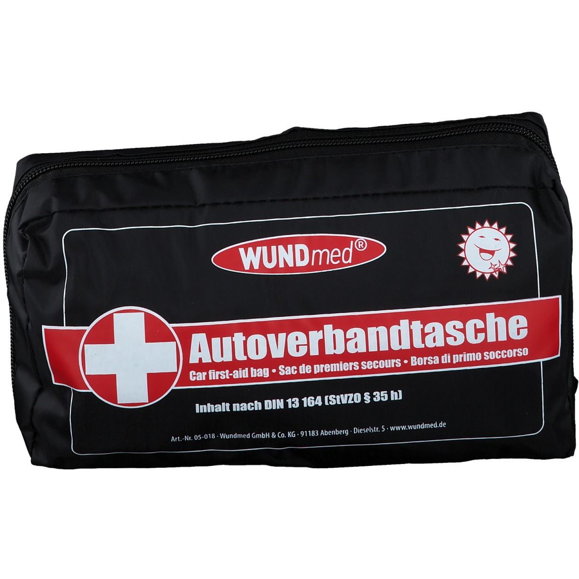 Zwarte tas met rode streep en wit kruis. Opschrift: WUNDmed, Autoverbandtasche, volgens DIN 13 164.