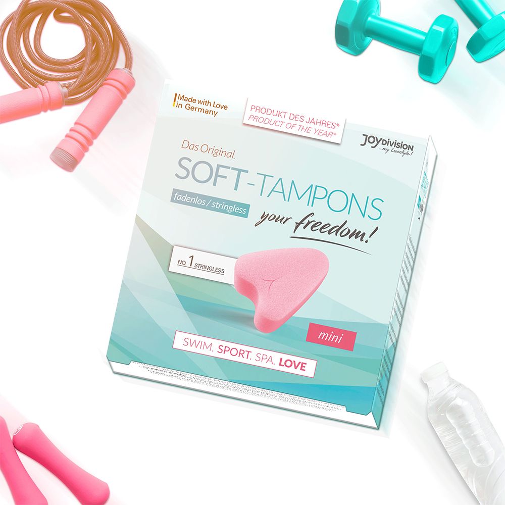 Productafbeelding met Soft-Tampons mini verpakking. Roze tampon afgebeeld. Tekst: fadenlos/stringless, SWIM. SPORT. SPA. LOVE.