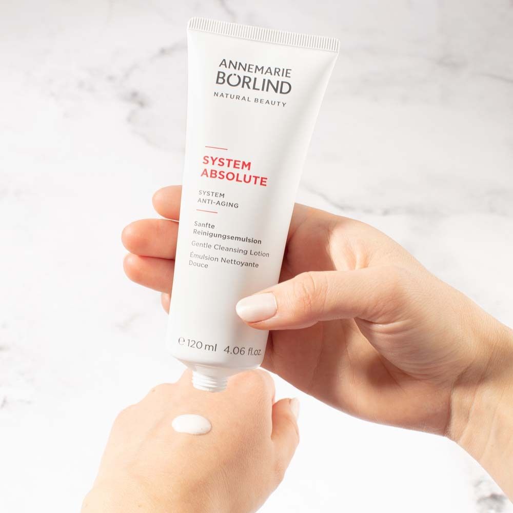 Witte tube met product. Product wordt op de hand aangebracht. Gouden sluiting.