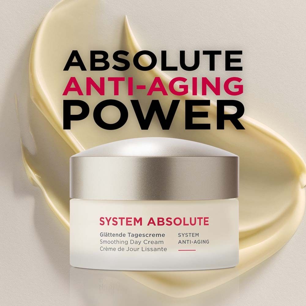 Crèmepot op gele achtergrond. Opschrift: SYSTEM ABSOLUTE, Glättende Tagescreme, Smoothing Day Cream, Crème de Jour Lissante.