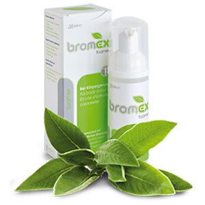 Witte dispenser en verpakking met groen logo en opschrift 'bromex foamer'. Groene plant op de voorgrond.